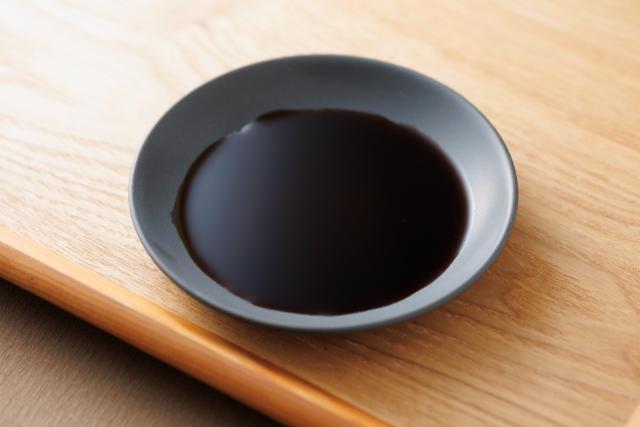 写真：黒い皿につがれた醤油の様子